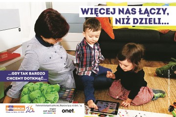 Chłopiec i dziewczynka wspólnie bawią się tabletem. Chłopiec, który nie ma rąk obsługuje urządzenie stopą. Przed nimi napis: Więcej nas łączy, niż dzieli