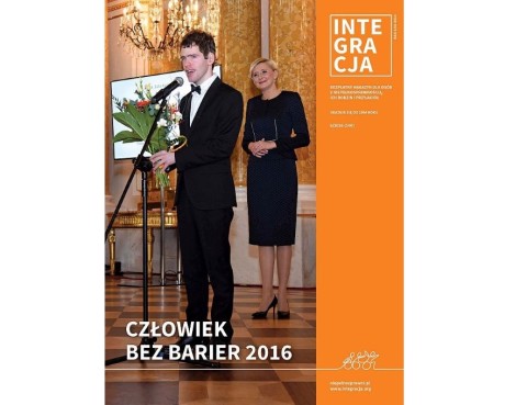 Okładka magazynu Integracja, a na niej Grzegorz Płonka, Człowiek bez barier 2016. Za nim stoi Agata Kornhauser-Duda, Małżonka Prezydenta RP