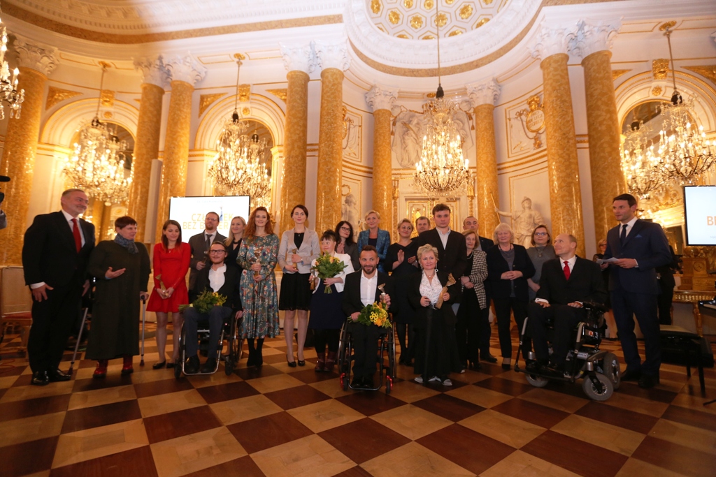 Wspólne zdjęcie laureatów 15. Konkursu Człowiek bez barier oraz oficjeli, wręczających i prowadzących Galę