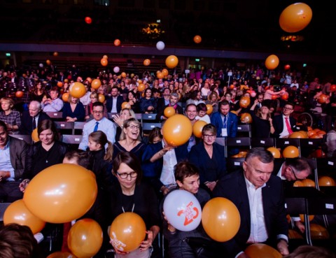 tłum publiczności na wielkiej gali bawi się spadającymi z syfitu balonikami